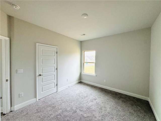 unfurnished bedroom with baseboards, carpet, and visible vents