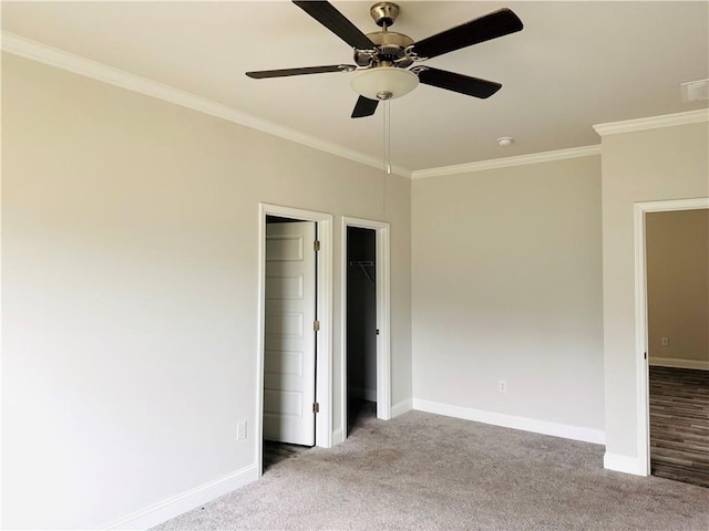 unfurnished bedroom featuring baseboards, ornamental molding, carpet flooring, and ceiling fan