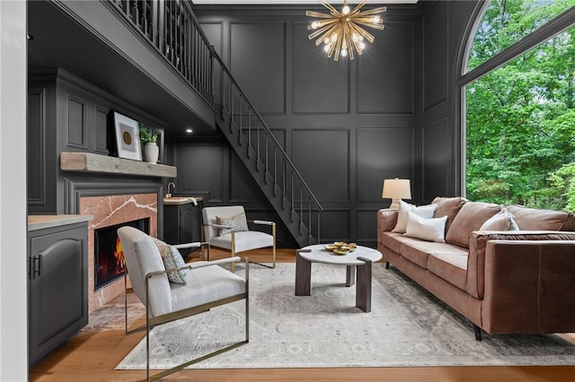 12995 Bucksport Dr, Roswell, GA 30075 - living area featuring a decorative wall, stairs, a chandelier, light wood finished floors, and a fireplace