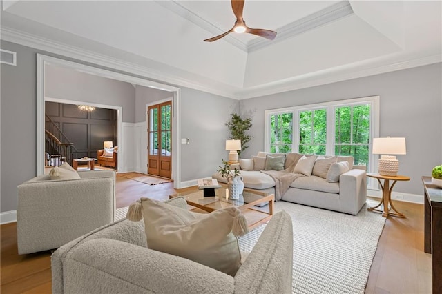 12995 Bucksport Dr, Roswell, GA 30075 - living room with a tray ceiling, crown molding, a ceiling fan, light wood finished floors, and stairs