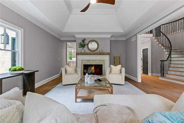12995 Bucksport Dr, Roswell, GA 30075 - living room featuring a tray ceiling, stairs, wood finished floors, ceiling fan, and baseboards