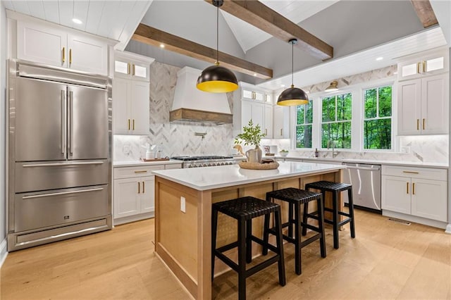 12995 Bucksport Dr, Roswell, GA 30075 - kitchen with stainless steel appliances, premium range hood, white cabinetry, decorative backsplash, and light countertops