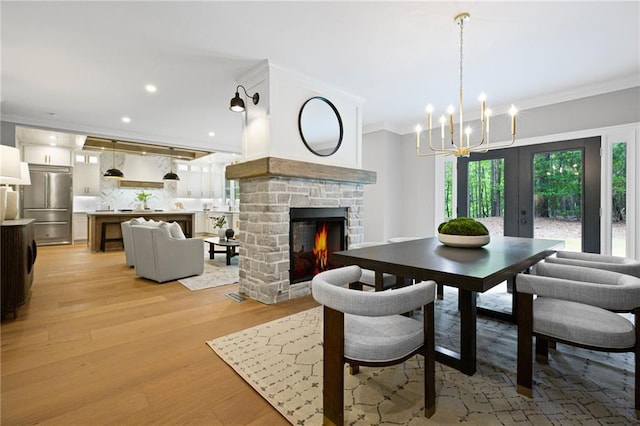 12995 Bucksport Dr, Roswell, GA 30075 - dining space with ornamental molding, a fireplace, light wood-style flooring, a chandelier, and recessed lighting