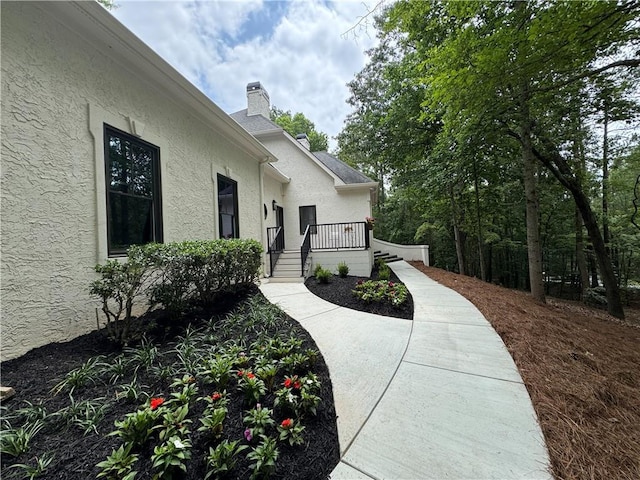 12995 Bucksport Dr, Roswell, GA 30075 - doorway to property featuring stucco siding, a chimney, and a deck
