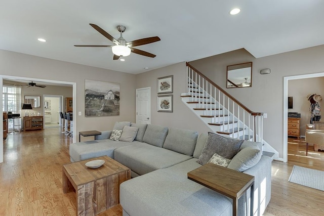 living room featuring light hardwood / wood-style flooring and ceiling fan