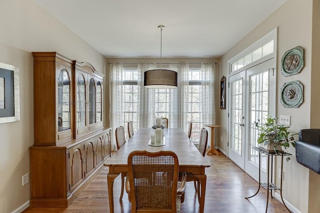 dining area with french doors and light wood-type flooring