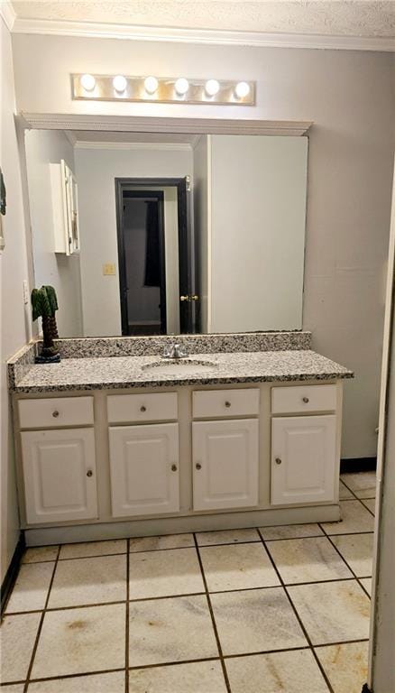 bathroom featuring ornamental molding, tile patterned flooring, vanity, and a textured ceiling