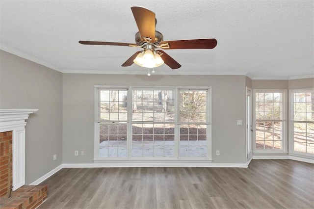 unfurnished living room with wood-type flooring, a brick fireplace, and crown molding