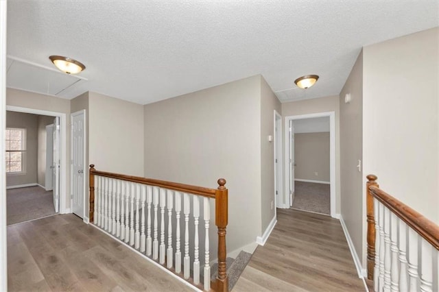 corridor featuring light hardwood / wood-style floors and a textured ceiling