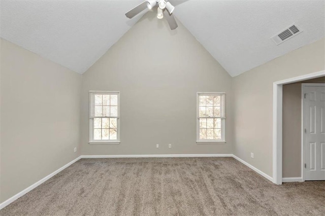 carpeted empty room with ceiling fan and high vaulted ceiling