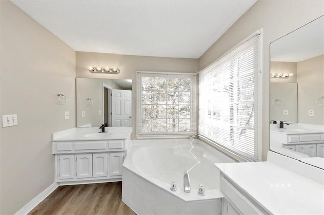 bathroom with hardwood / wood-style flooring, a bathing tub, and vanity