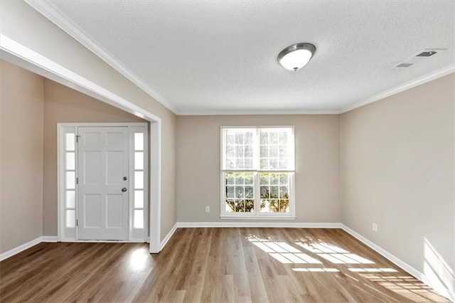 foyer with hardwood / wood-style floors, crown molding, and a textured ceiling