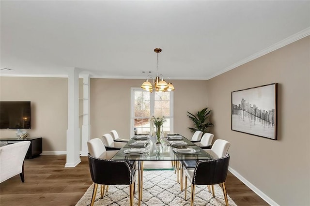 dining space with ornate columns, ornamental molding, hardwood / wood-style flooring, and a chandelier