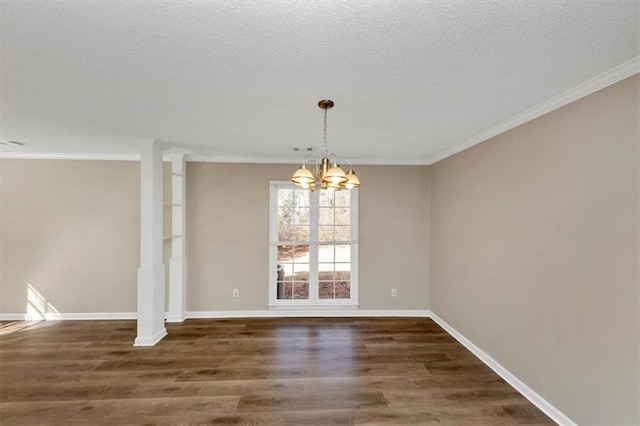 unfurnished dining area featuring dark wood-type flooring, ornamental molding, a textured ceiling, and a notable chandelier