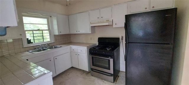 2980 Wanda Cir SW, Atlanta, GA 30315 - kitchen with freestanding refrigerator, stainless steel gas range, under cabinet range hood, a sink, and tile counters