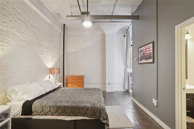 bedroom featuring ensuite bath, ceiling fan, and brick wall