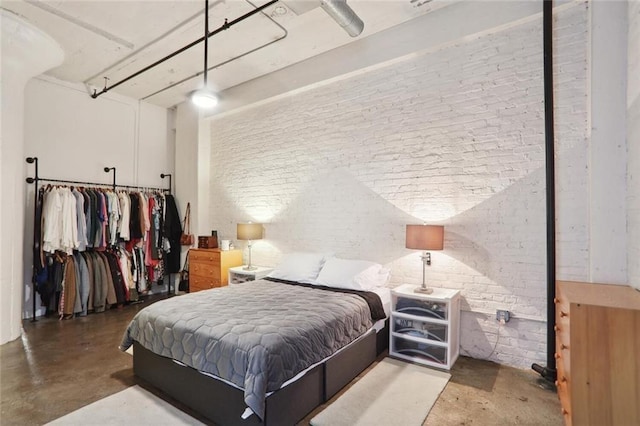 bedroom featuring concrete floors, ceiling fan, and brick wall