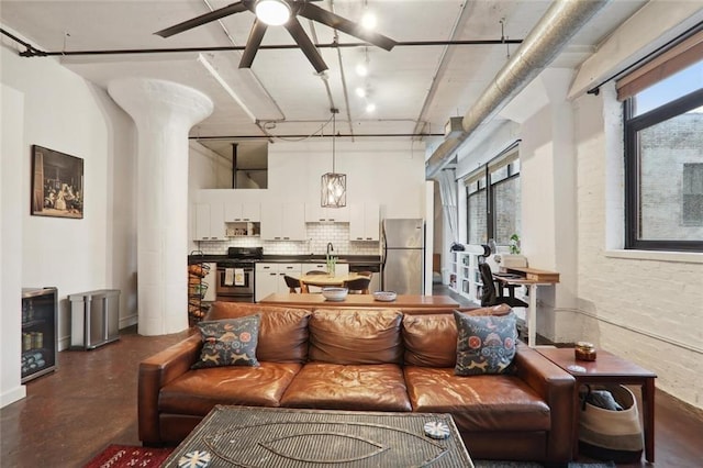 living room featuring ceiling fan, sink, and a wealth of natural light