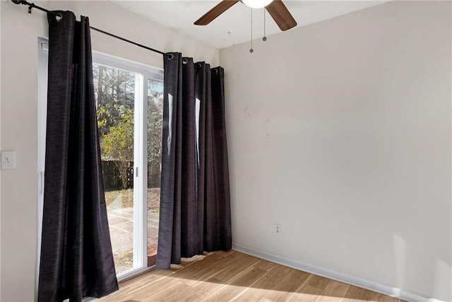 spare room featuring ceiling fan, a wealth of natural light, and light hardwood / wood-style flooring