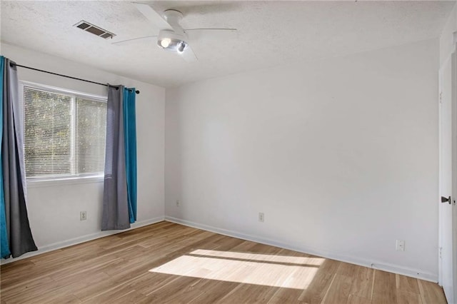 spare room with ceiling fan and light wood-type flooring