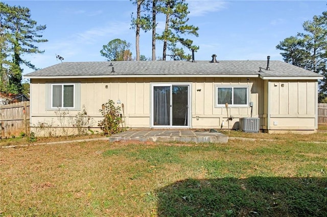 rear view of property featuring a yard and cooling unit