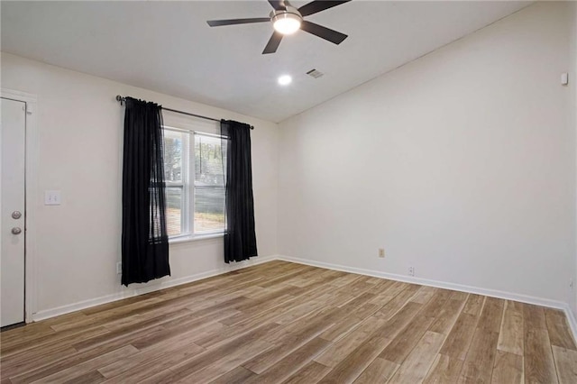 spare room with ceiling fan, wood-type flooring, and vaulted ceiling