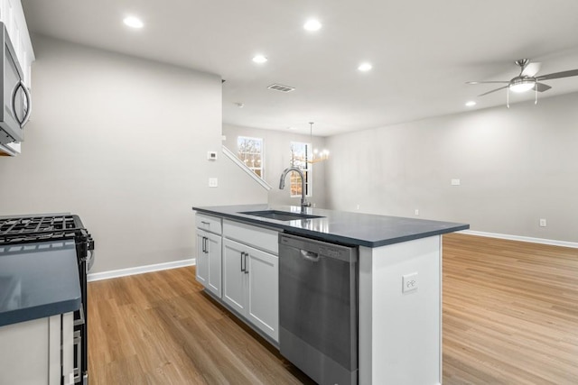 kitchen featuring sink, appliances with stainless steel finishes, an island with sink, pendant lighting, and white cabinets