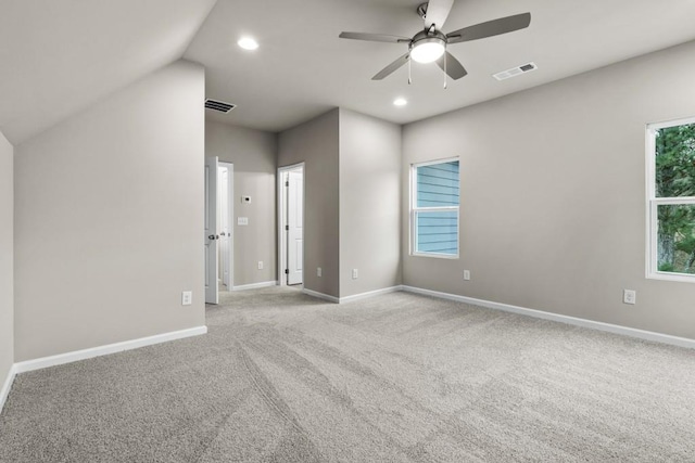 empty room featuring lofted ceiling, light carpet, and ceiling fan