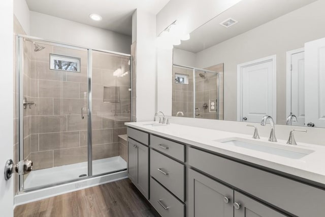 bathroom with walk in shower, vanity, and hardwood / wood-style floors