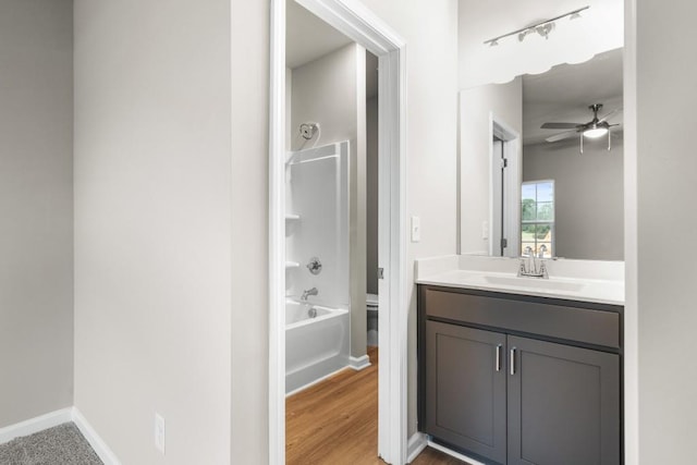 full bathroom with shower / tub combination, hardwood / wood-style flooring, vanity, ceiling fan, and toilet