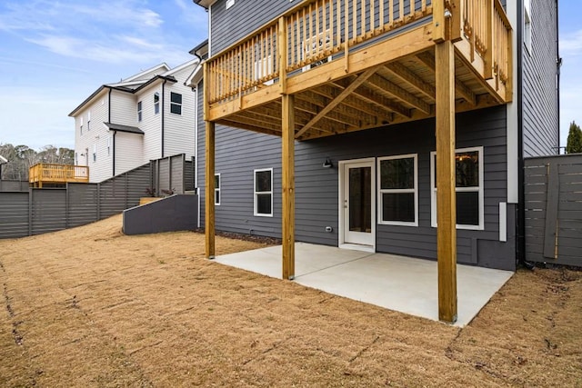 back of house with a deck and a patio