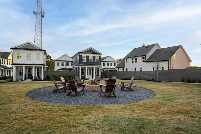 rear view of property with an outdoor fire pit, a yard, and a patio