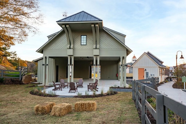 back of property featuring a yard, a patio area, and a fire pit