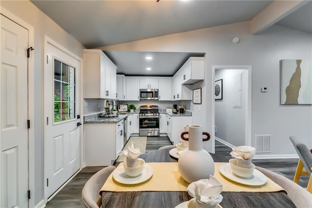 2162 Westover Dr, Atlanta, GA 30344 - kitchen featuring appliances with stainless steel finishes, dark wood-style flooring, a sink, white cabinets, and recessed lighting