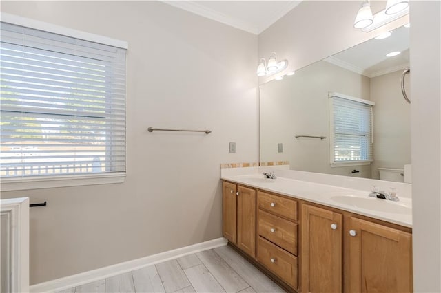 full bathroom featuring toilet, a sink, baseboards, double vanity, and crown molding