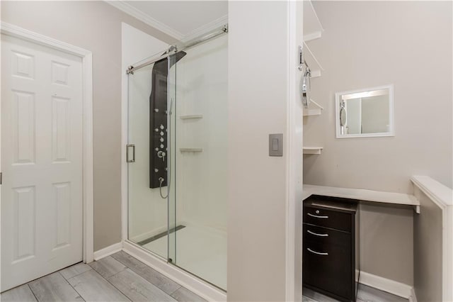 full bath featuring ornamental molding, a stall shower, wood finish floors, and baseboards