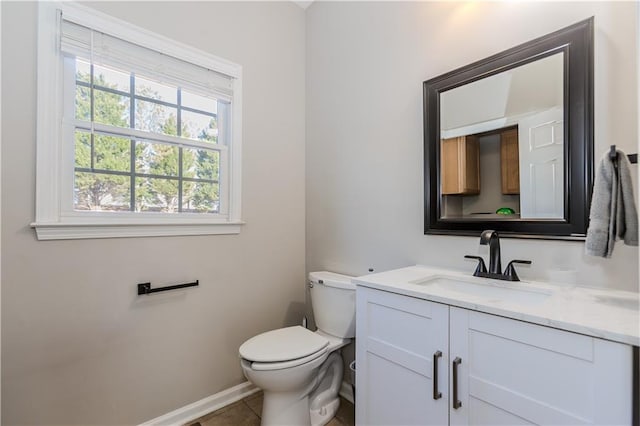 bathroom featuring tile patterned flooring, baseboards, vanity, and toilet