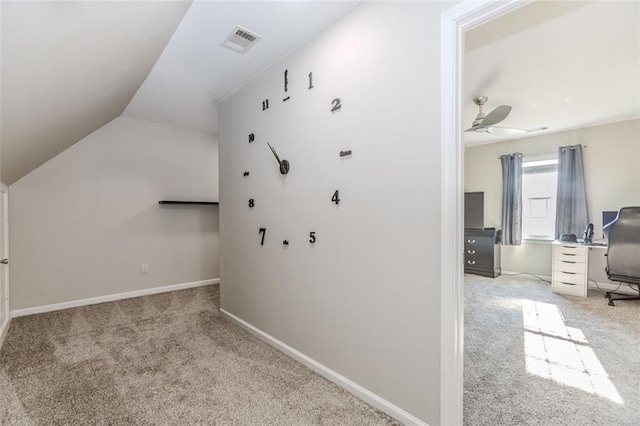 interior space featuring lofted ceiling, light colored carpet, visible vents, ceiling fan, and baseboards