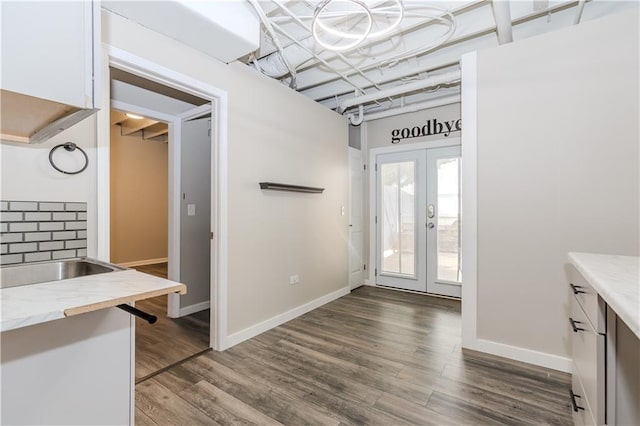 interior space featuring dark wood-style floors, french doors, and baseboards