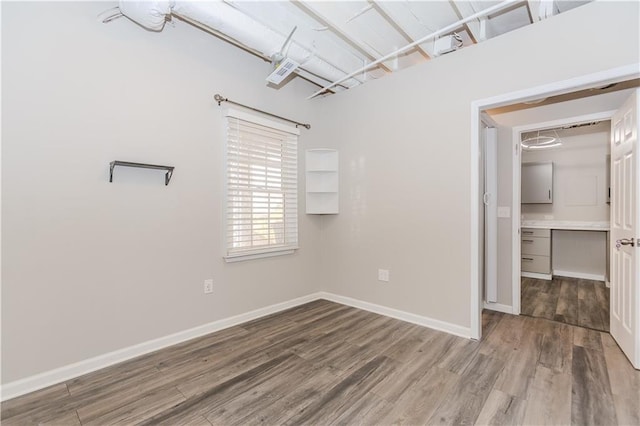 empty room featuring baseboards and wood finished floors