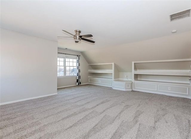 additional living space featuring light carpet, visible vents, baseboards, vaulted ceiling, and a ceiling fan