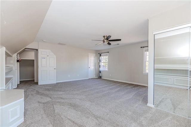 unfurnished bedroom with light carpet, lofted ceiling, a ceiling fan, and baseboards