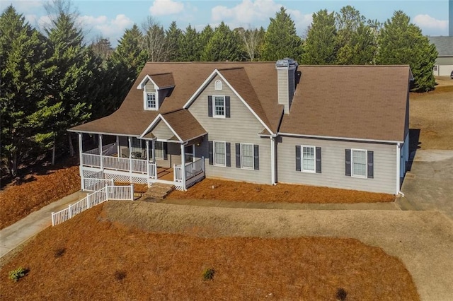 view of front of house featuring a chimney and a porch