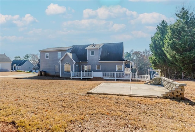 rear view of property featuring a yard and a patio