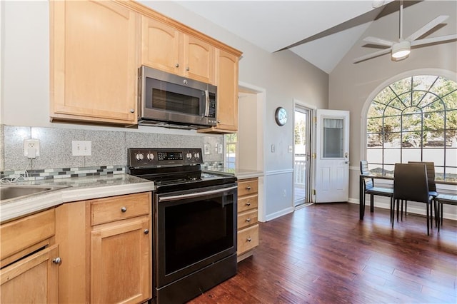 kitchen featuring light countertops, stainless steel microwave, light brown cabinetry, vaulted ceiling, and range with electric cooktop