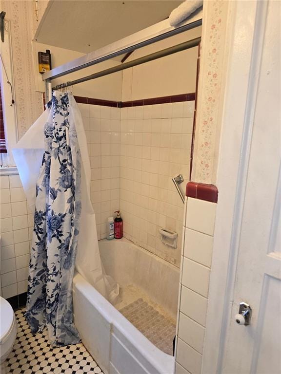 bathroom with toilet, shower / tub combo, and tile patterned floors