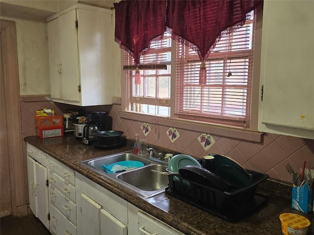 kitchen featuring white cabinets and sink