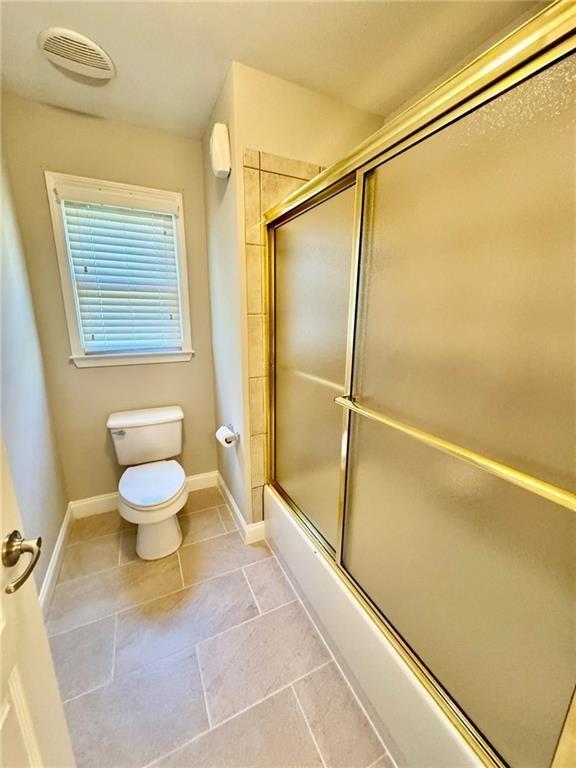 2822 Salem Oak Way, Duluth, GA 30096 - bathroom with toilet, combined bath / shower with glass door, baseboards, and tile patterned floors
