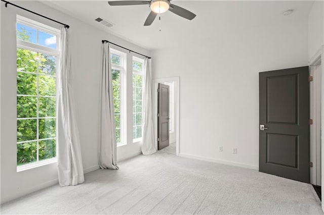 carpeted spare room with ceiling fan