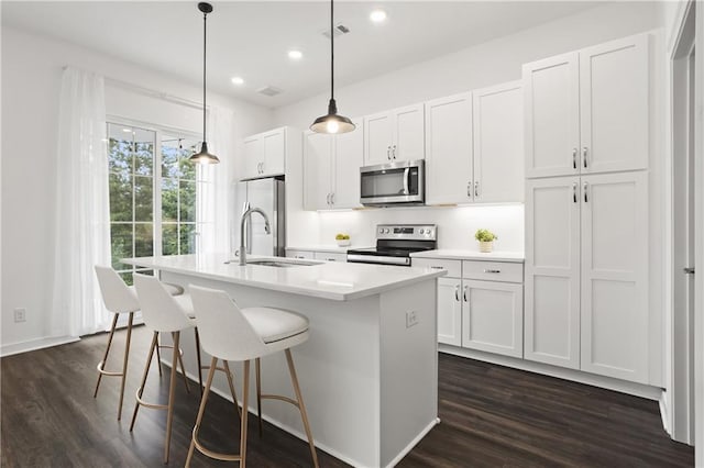 kitchen with white cabinets, sink, an island with sink, and appliances with stainless steel finishes